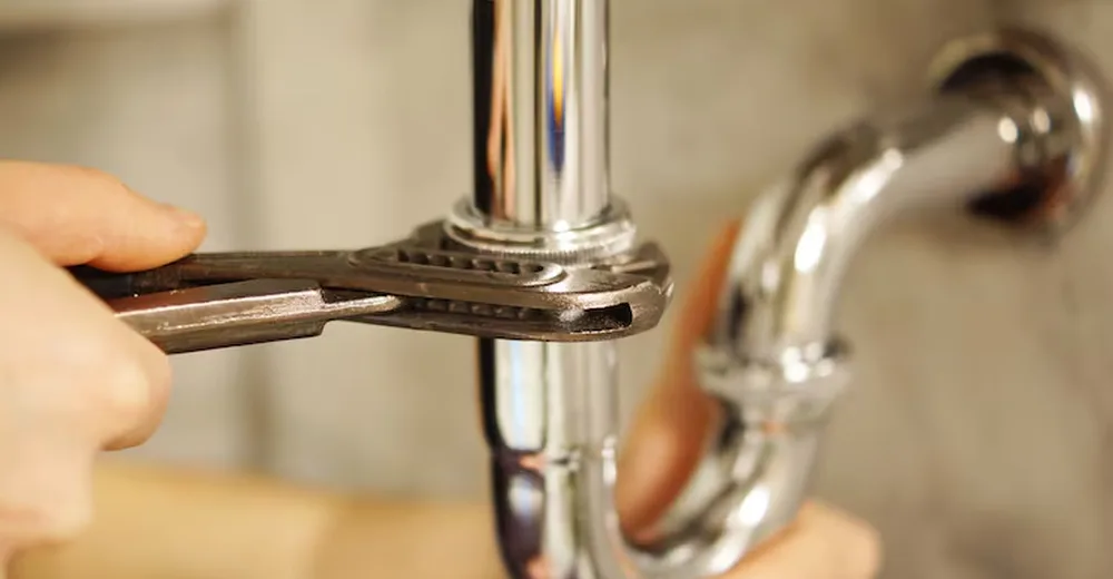 Eau chaude versée dans une évacuation de cuisine propre